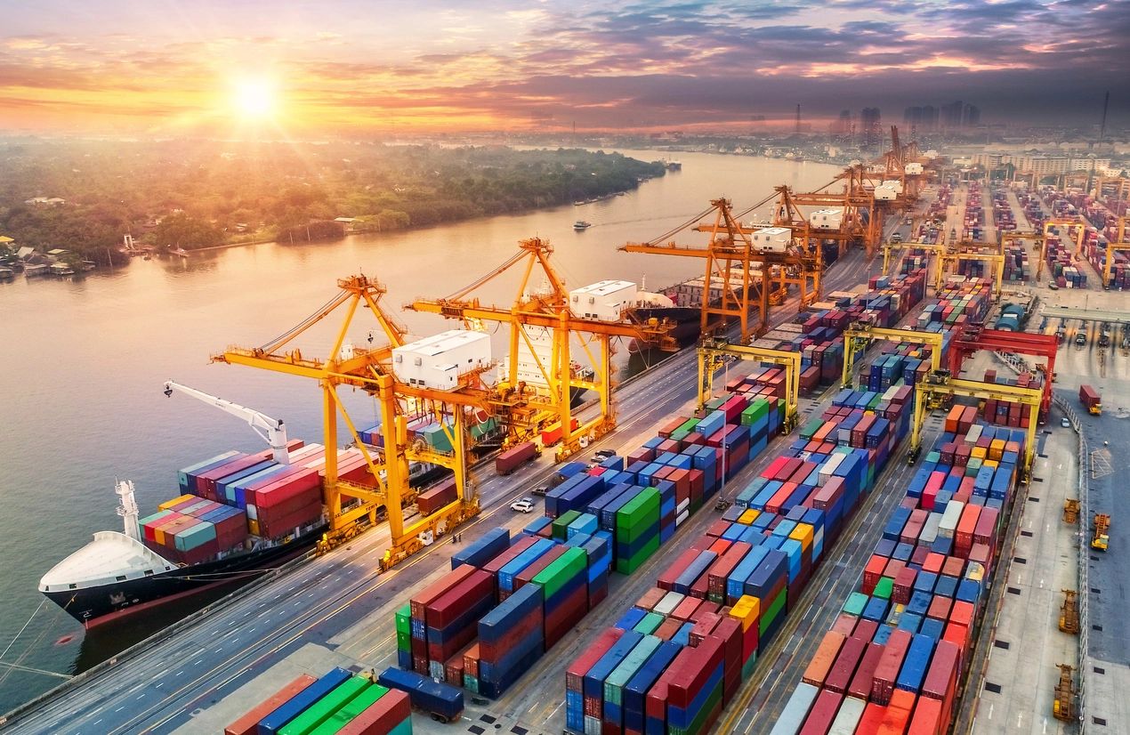 Container port and cargo terminal along a river at sunrise